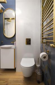 W łazience znajduje się biała toaleta i lustro. w obiekcie Golden Villa Saska Kępa w Warszawie