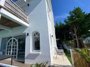 a white house with a chair on a patio at Villa face mer in Royan