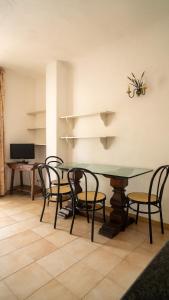 uma sala de jantar com uma mesa de vidro e cadeiras em Residence Palummera em Ischia