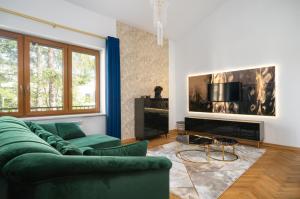 sala de estar con sofá verde y chimenea en Golden Villa Saska Kępa en Varsovia