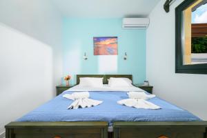 a bedroom with a blue bed with white pillows at Elen-Mari in Hersonissos