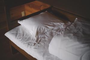 een bed met witte lakens en kussens erop bij Premium villa glamping log cabin with stars and bonfire in Hokuto