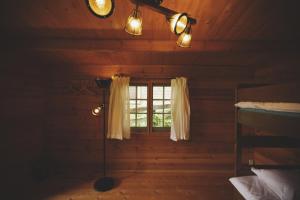 Premium villa glamping log cabin with stars and bonfire في هوكوتو: غرفة مع نافذة في كابينة خشب