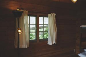 Premium villa glamping log cabin with stars and bonfire في هوكوتو: غرفة بها نافذة بها ضوء ومصباح