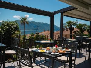 a table with food on a balcony with a view at Hotel Sole in Cannero Riviera