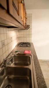 um balcão de cozinha com um lavatório e um fogão em Residence Palummera em Ischia