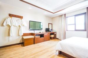 a bedroom with a bed and a flat screen tv at Hotel Charlot Castle in Pyeongtaek