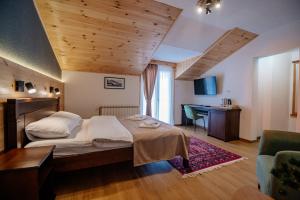 a bedroom with a bed and a desk in a room at Hotel Zlatni bor in Žabljak