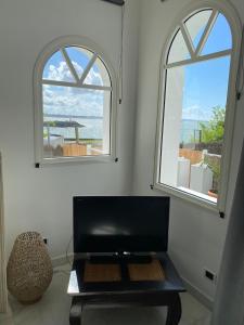 a living room with two windows and a table at Villa face mer in Royan