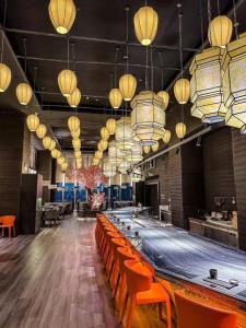a large bar with orange chairs and lights at Guangzhou Tianhe Taikoohui - Coffee Rupin Hotel,Canton Fair Free Shuttle Bus in Guangzhou