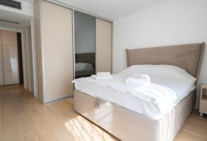 - une chambre dotée d'un grand lit blanc avec des miroirs aux murs dans l'établissement Sarajevo Waves Aparthotel, à Sarajevo