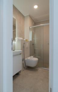ein Bad mit einer Dusche, einem Waschbecken und einem WC in der Unterkunft Sarajevo Waves Aparthotel in Sarajevo