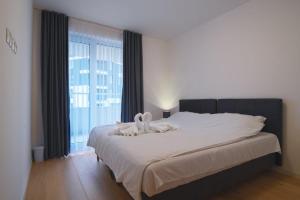 a bedroom with a large bed with a large window at Sarajevo Waves Aparthotel in Sarajevo