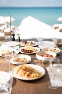 a table with white plates of food on it at ĪKYMA Boutique in Polychrono
