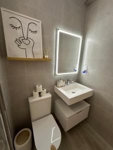 Un baño con inodoro, lavabo y espejo. en Apartamento Andalucía 33 Izquierda, en Málaga 12 fotos más