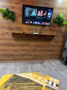 een tv aan een houten muur in een woonkamer bij Бектурова 15 in Pavlodar