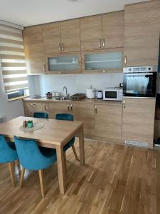 cocina con mesa de madera y sillas azules en Apartment Nikolic, en Zlatibor