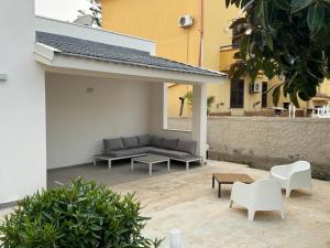 - une terrasse avec un canapé et des chaises dans un bâtiment dans l'établissement Villa da "Giacomino l'Americano", à Cinisi