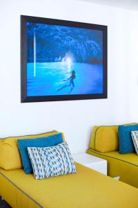 une télévision suspendue sur un mur au-dessus d'un canapé dans l'établissement Hotel Tasso Suites & Spa, à Sorrente