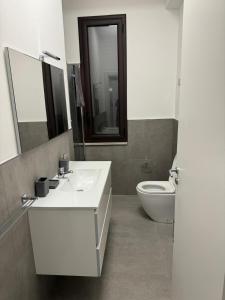 La salle de bains est pourvue d'un lavabo blanc et de toilettes. dans l'établissement Villa da "Giacomino l'Americano", à Cinisi
