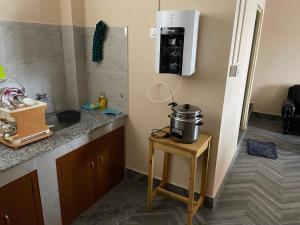 a kitchen with a counter with a coffee pot on a table at Keeon Private Room Front in Shillong