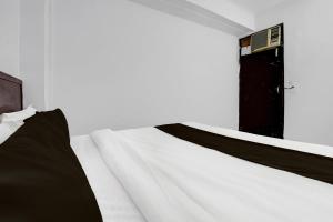 Kālkāji Devi的住宿－OYO Hotel Wamson，卧室配有白色的床和黑色的门