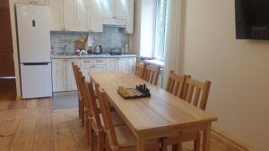 a kitchen with a wooden table with chairs and a refrigerator at Petit Dilijan in Dilijan