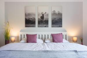 a bedroom with a bed with two pictures of a deer at Ferienwohnung Almwiesen in Obermaiselstein