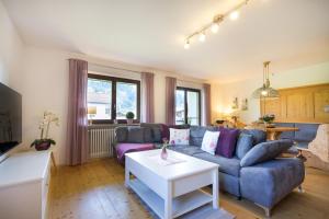 a living room with a blue couch and a table at Ferienwohnung Almwiesen in Obermaiselstein