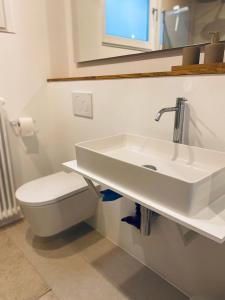 ein Badezimmer mit einem weißen Waschbecken und einem WC in der Unterkunft Lay-Zeit in Kottenheim