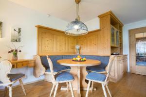 a kitchen with a wooden table and chairs at Ferienwohnung Almwiesen in Obermaiselstein