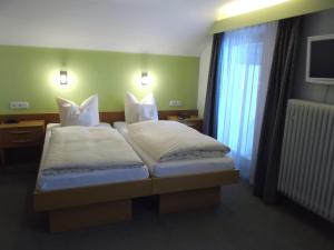 a bedroom with two beds and a window at Hotel Bavaria in Bad Wiessee