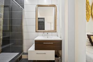 y baño con lavabo y espejo. en La Suite Indivio - Appartement standing vue cathédrale en Dijon