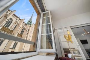 um quarto com uma janela com vista para uma igreja em La Suite Indivio - Appartement standing vue cathédrale em Dijon