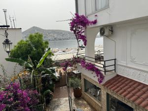a balcony of a building with purple flowers at Vila Onhezmi in Sarandë