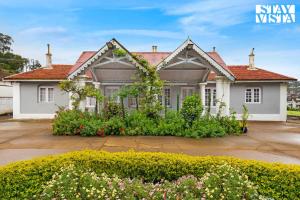 a white house with a red roof at StayVista at The Alcove with Breakfast & BBQ Grill in Ooty