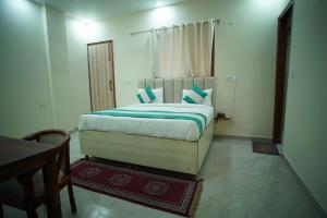 1 dormitorio con 1 cama grande con almohadas azules en icyhotels ADA residency and confrence centre, en Noida