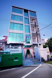 un edificio alto con una puerta verde delante de él en icyhotels ADA residency and confrence centre, en Noida