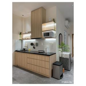a kitchen with wooden cabinets and a microwave at Hạ Home Huế - Căn hộ riêng tư trung tâm 2 phòng ngủ in Hue +16 photos
