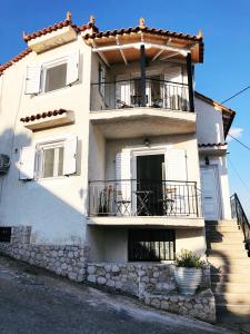 een groot wit gebouw met balkons in een straat bij Endless View Home in Nafplio in Ária