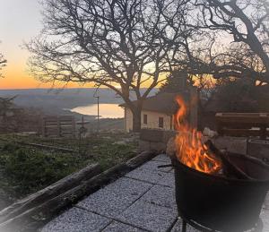 a fire pit on a patio with the sunset in the background at Piccola Sorpresa Il preferito degli escursionisti sul Cammino in Scoppieto