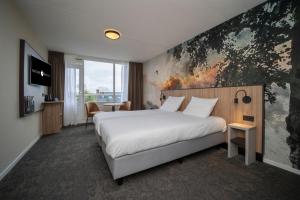a hotel room with a bed and a large painting on the wall at Fletcher Hotel-Restaurant Langewold in Roden +118 photos