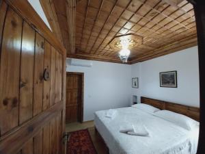 um quarto com uma cama e um tecto de madeira em Guest House J.Prifti em Berati