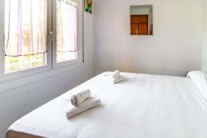 a white bed with two towels on top of it at Carboneras 45 - Apartamento con terraza in Girona