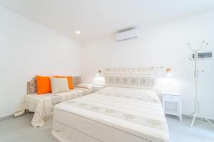 biała sypialnia z 2 łóżkami i kanapą w obiekcie Brorent Affittacamere moro dream rooms w mieście Olbia