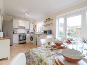 a kitchen and dining room with a table and chairs at 23 Church Farm Lane in Halesworth