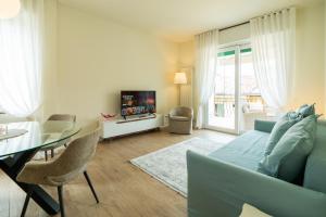 Domus Verona - Ampia residenza Filippini a pochi passi dall'Arena في فيرونا: غرفة معيشة مع أريكة زرقاء وطاولة