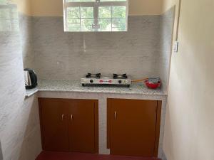 a kitchen with a stove and a counter top at Keeon Private Room Back in Shillong