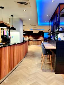 a bar with a counter and a bar stool at Holiday Inn Birmingham North - Cannock, an IHG Hotel in Cannock