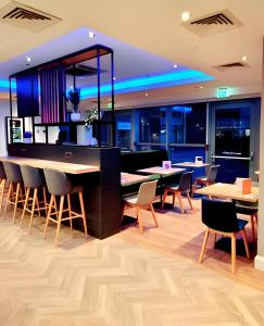 a bar in a restaurant with tables and chairs at Holiday Inn Birmingham North - Cannock, an IHG Hotel in Cannock
